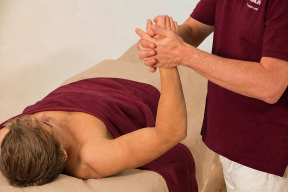 Touchlife Massage - Arme Eine Person erhält eine Handmassage von einer anderen Person.
